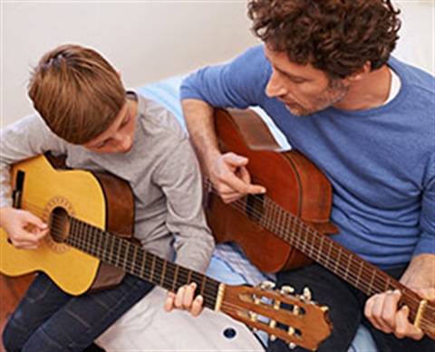 man giving boy guitar lessons