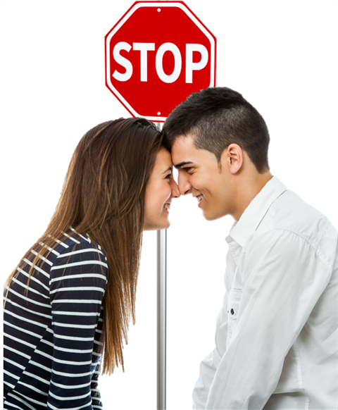 Boy and Girl looking at each other with stop sign between them