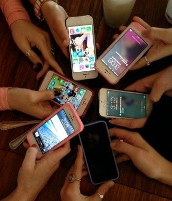 Multiple Cell Phones forming a circle in people's hands