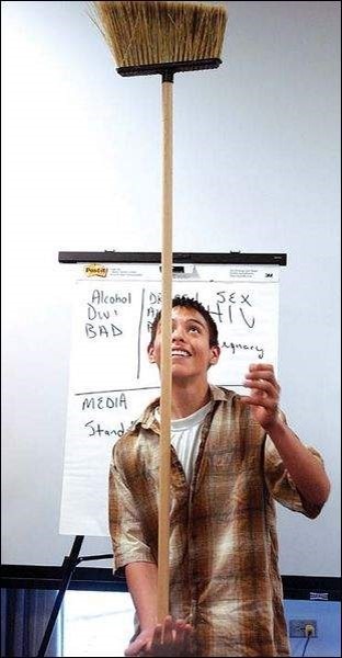 High School Student balancing broom on palm of hand