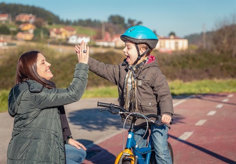 Mom and young boy on bike_high five.jpg